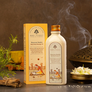 Baby Forest Maasoom Maalish Baby Body Massage Oil with packaging on a dark surface with smoke and plants.