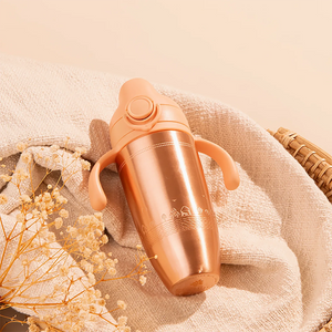 Tiny Tamba Pure Copper Sipper for Kids on a soft beige fabric background with dried flowers.
