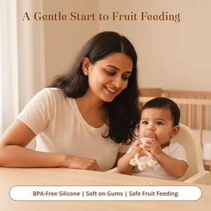 A smiling woman sits beside a baby in a high chair, who is chewing a Laalan Paalan Baby Fruit Pacifier. The scene is set in a warm, softly lit nursery with text reading 'A Gentle Start to Fruit Feeding' and 'BPA-Free Silicone | Soft on Gums | Safe Fruit Feeding'.