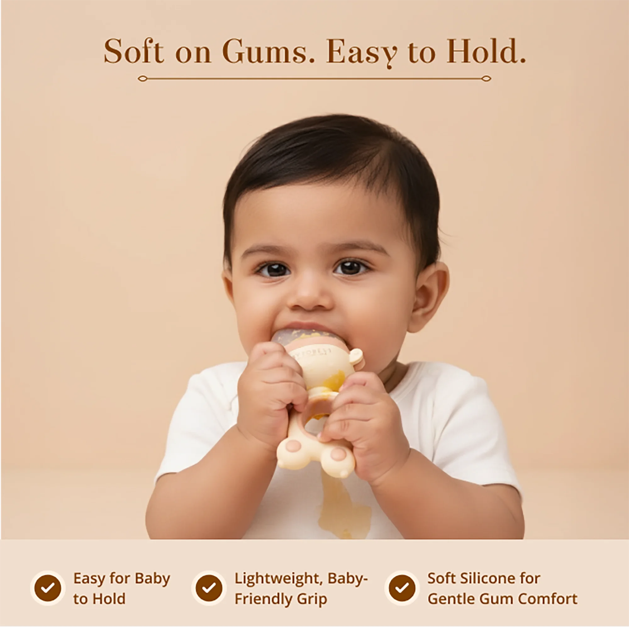 A baby is shown holding and biting a Laalan Paalan Baby Fruit Pacifier against a warm beige background with marketing text "soft on gums. Easy to hold" 