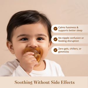 A baby wearing a white onesie holds a Sneh Dulaar Baby Pacifier to their mouth against a warm beige background. Three white callout bubbles with brown checkmarks list benefits: calming fussiness and supporting better sleep, no nipple confusion or feeding disruption, and zero gels, chillers, or gimmicks.