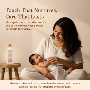 A woman in a white outfit holds and massages a baby while seated on the floor. A small wooden stool beside her holds a Maasoom Maalish Baby Body Massage Oil.