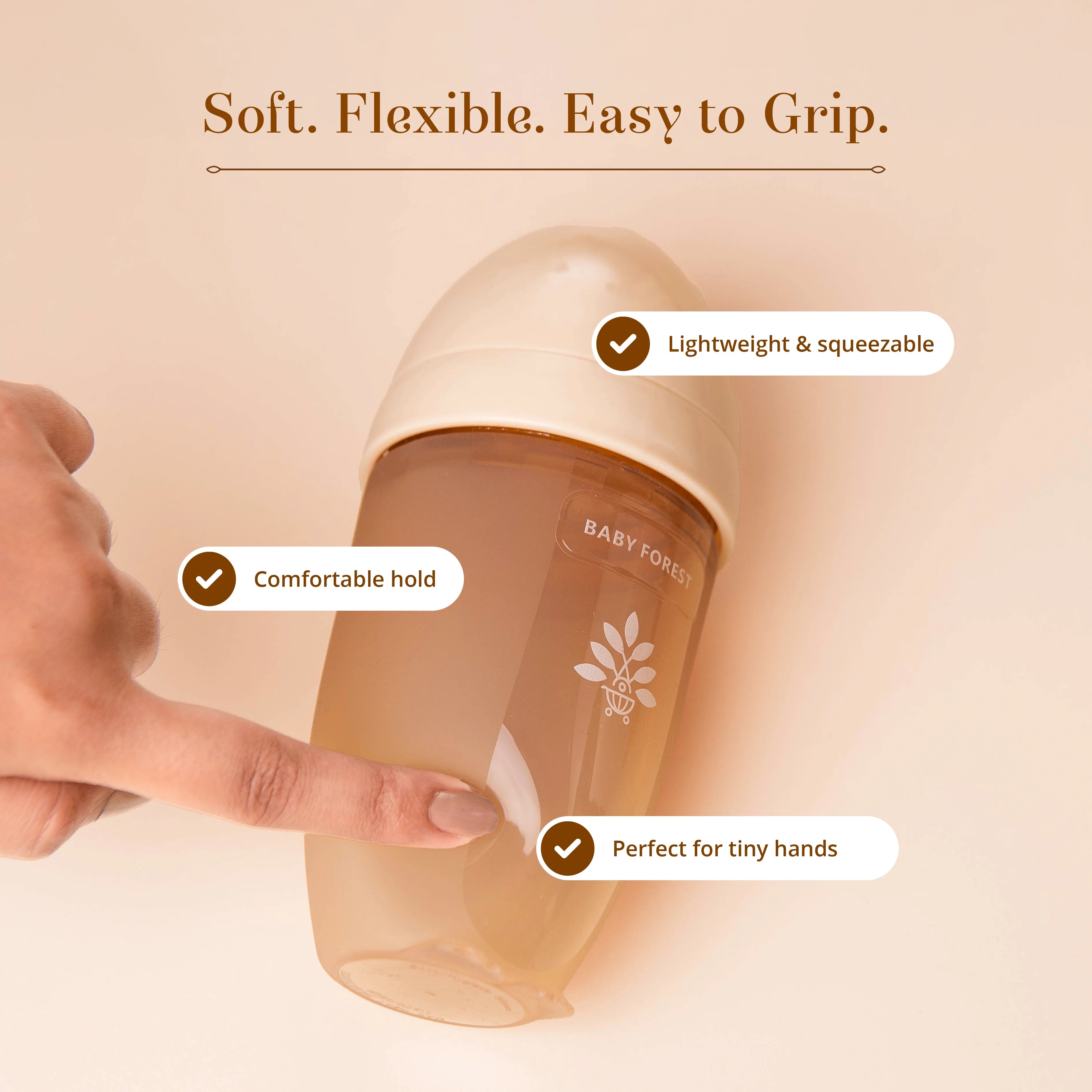 A Laad Pyaar Baby Feeding Bottle with a translucent amber body and a cream-colored cap, shown with a hand holding it.