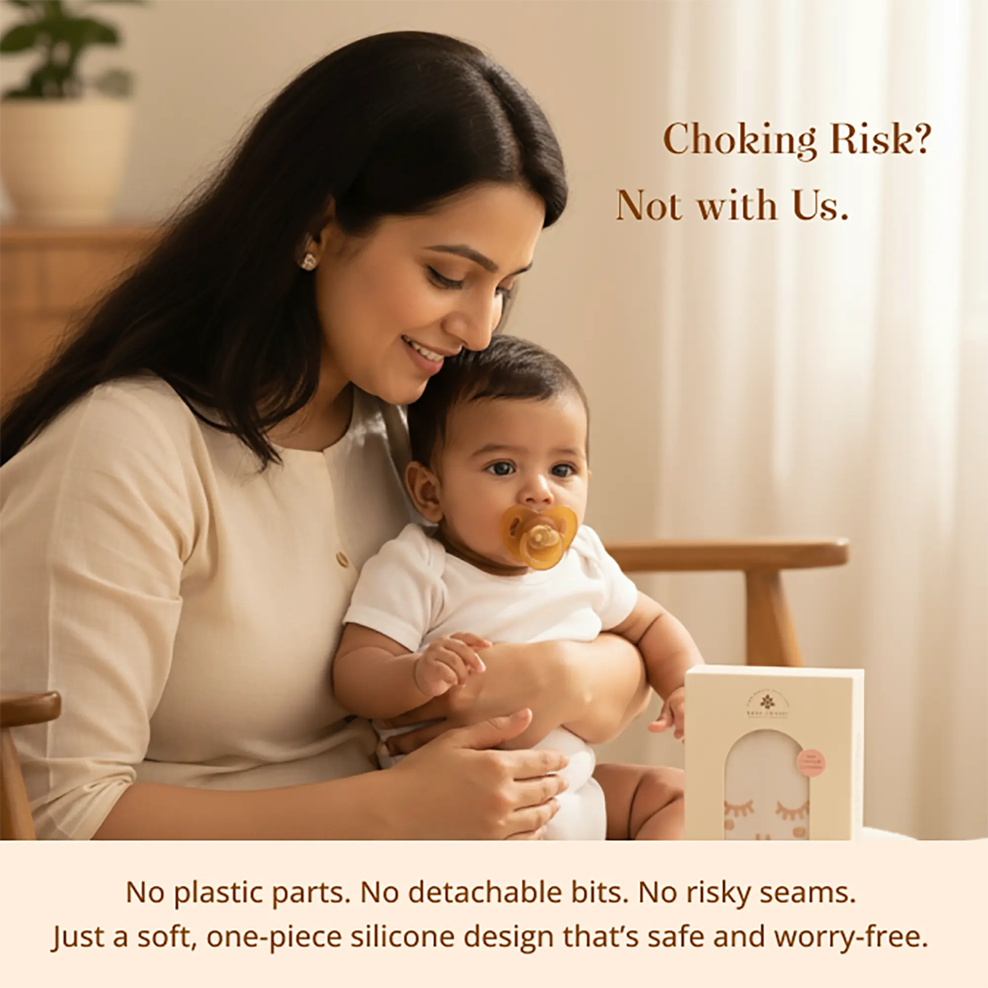 A woman holding a baby in a soft cream outfit in a warm indoor setting, with text reading 'Choking Risk? Not with Us.' and a Sneh Dulaar Baby Pacifier Box visible on the table. 
