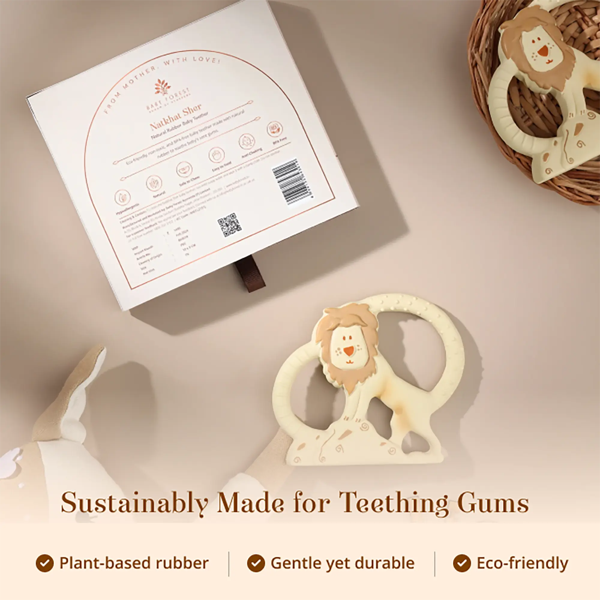 A Natkhat Sher Natural Rubber Baby Teether with a circular ring handle is shown on a beige surface, alongside its branded product box and a wicker basket containing a similar item. Text at the bottom reads 'Sustainably Made for Teething Gums' with feature callouts.