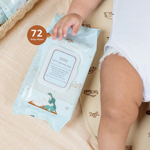 Baby hand holding a package of Neer 99.9% Water Wipes on a beige surface